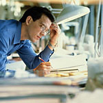 Image of man studying papers on a table